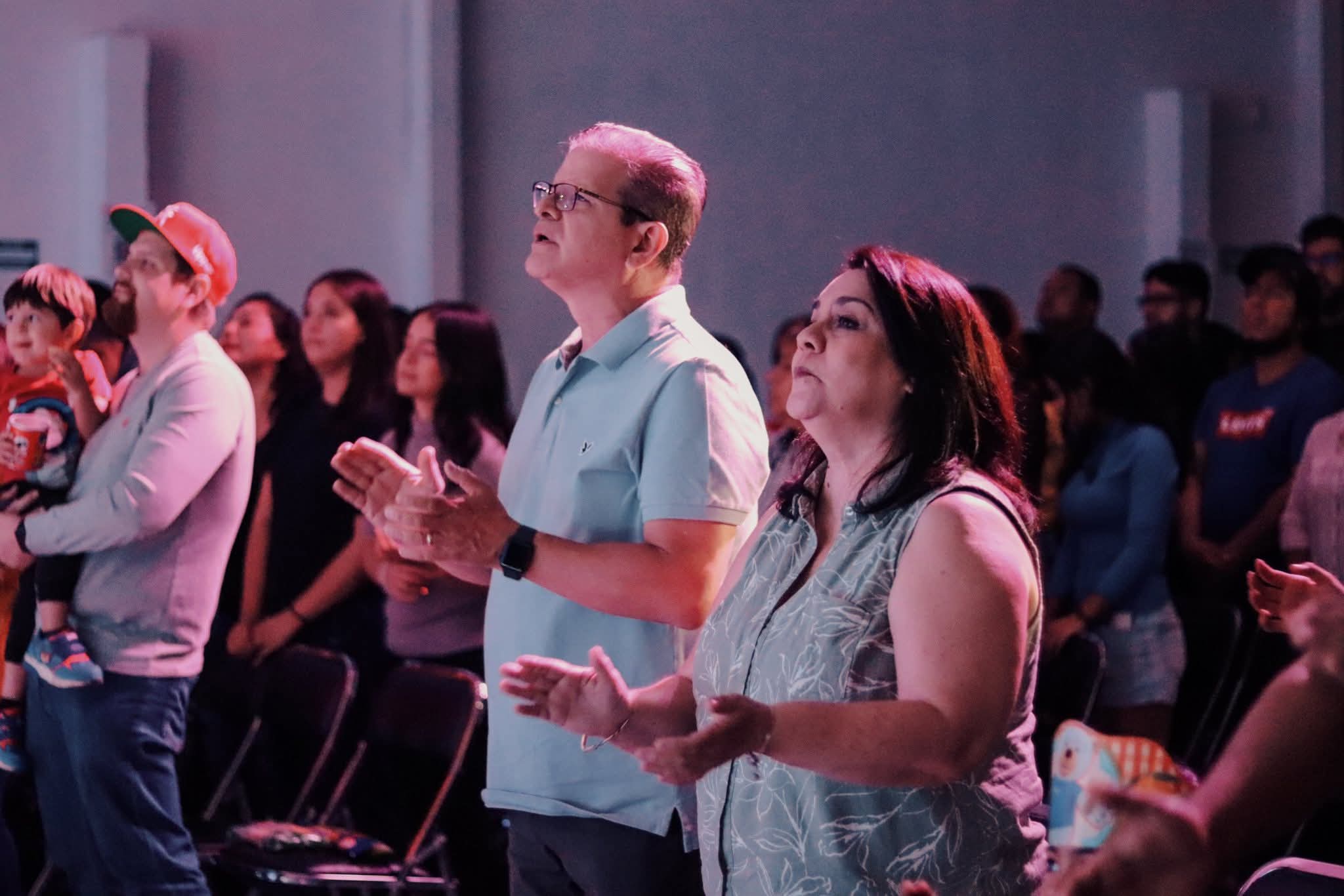 Pareja y gente aplaudiendo y orando
